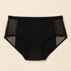 Black high-waisted underwear with mesh panels on a beige background