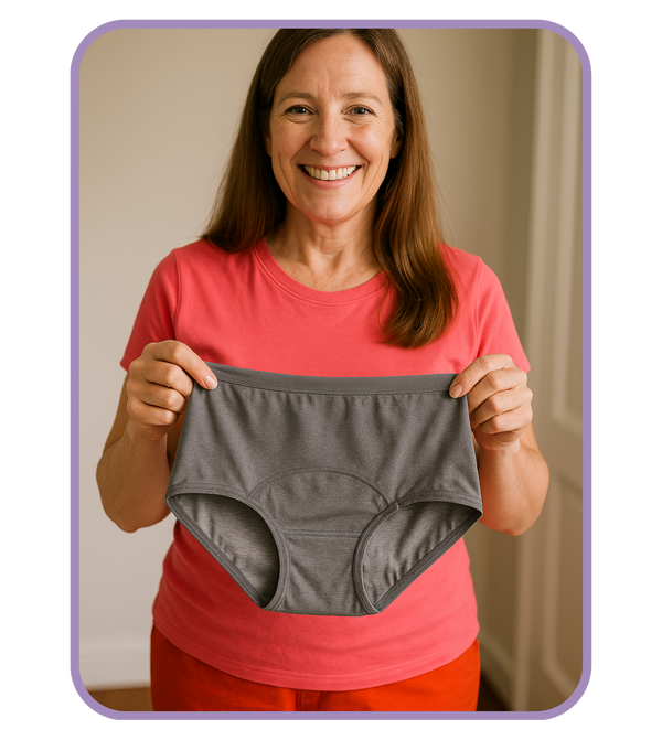 Woman holding gray underwear against a plain background