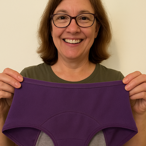 Person holding a purple underwear with a gray interior against a plain background